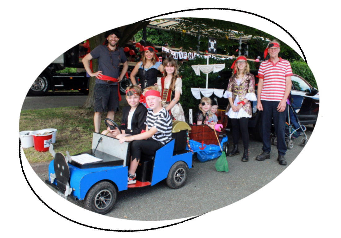 a photo of a family parade entry displaying as pirates which includes a small pirate ship